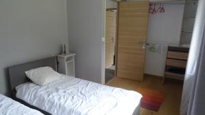a bedroom with a white bed and a shower at Pinede in Labenne +6 photos