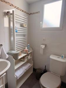 a white bathroom with a toilet and a sink at La maisonnette in Forêt-la-Folie