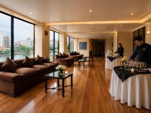 two people standing in a room with tables with wine glasses at LRH Viña del Mar and Convention Center - Ex Gala Hotel in Viña del Mar +51 photos
