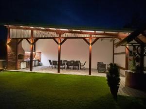 a pavilion with a table and chairs in a yard at Pensiunea Anna in Poplaca