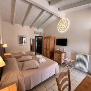 a bedroom with two beds and a flat screen tv at Relais Masseria Serritella in Castellana Grotte