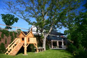 a wooden play house in front of a house at Vila Vinita in Sveti Jurij ob Ščavnici
