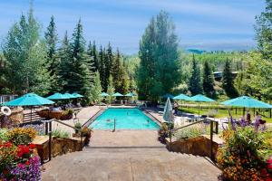 a swimming pool with blue umbrellas and flowers at Lion Square Lodge South 451 in Vail