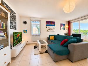 a living room with a blue couch and a tv at " Régussol Coloré " Piscine - Linge fourni - Wifi in Castelnau-dʼEstrétefonds