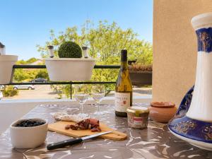 a table with a bottle of wine and two glasses at " Régussol Coloré " Piscine - Linge fourni - Wifi in Castelnau-dʼEstrétefonds +15 photos