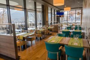 a restaurant with tables and chairs and windows at Hospedium Hotel Lleida in Graus
