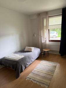 a bedroom with a bed and a table and a window at Opiskelijankatu 5 Varkaus in Varkaus +2 photos