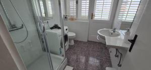a white bathroom with a toilet and a sink at Trogir apartments in Trogir +18 photos