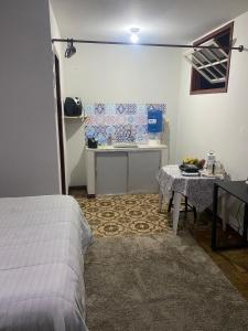 a bedroom with a bed and a table in a room at Kitnet Imperial in Ouro Preto
