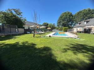 a yard with a swimming pool and a house at La Maison d'hôtes LA PUYERRE in Hours