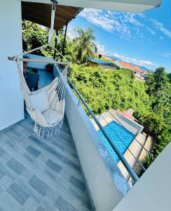 a hammock on a balcony with a swimming pool at Penthouse Jacuzzi Vista Serena cerca a centro Anapoima in Anapoima