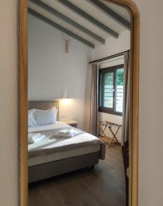 a bedroom with a bed and a large mirror at Kaia Studios Agnondas in Agnontas