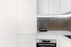 a white kitchen with white cabinets and a stove at Uno del Mar 2 in Vila Nova de Gaia +17 photos