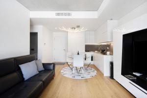a living room with a black couch and a kitchen at Uno del Mar 2 in Vila Nova de Gaia