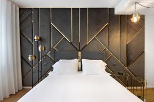 a bedroom with a large white bed with gold accents at Uno del Mar 2 in Vila Nova de Gaia