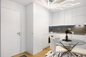 a kitchen with a glass table and white cabinets at Uno del Mar 2 in Vila Nova de Gaia