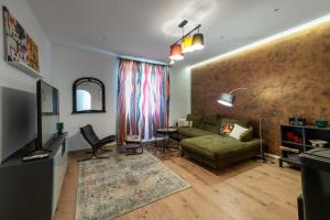 a living room with a couch and a television at Apartment Grof Janko - Luxury in the Center - TERRACE & FREE PARKING in Karlovac