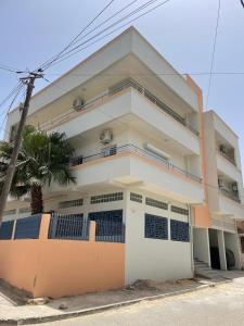 ein weiß-oranges Gebäude mit einem Zaun in der Unterkunft Cité Soleil in Dakar