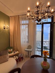 a living room with a dining room table and a chandelier at Utopia House & Garage in Kavála