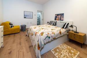 a bedroom with a bed and a yellow couch at Apartment Grof Janko - Luxury in the Center - TERRACE & FREE PARKING in Karlovac