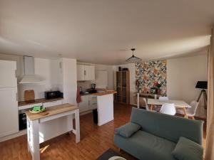 a living room with a couch and a kitchen at Le Moulin in Saint-Nolff