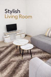 ein Wohnzimmer mit zwei Tischen und einem Sofa in der Unterkunft Kitale Comfy in Kitale