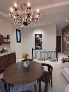 a living room with a table and a chandelier at Utopia House & Garage in Kavála