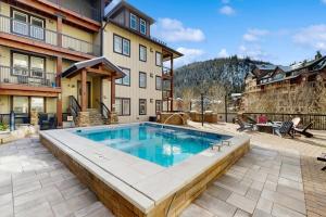 a swimming pool in the middle of a patio at Ski-In Ski-Out Modern Mountain Condo in Winter Park