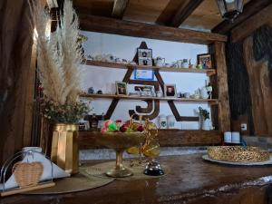 a table with a bowl of fruit and a clock on a shelf at Lukin salaš broj 3 in Ratkovo +11 photos