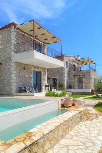 a villa with a swimming pool and a house at Elements Villas in Paleros