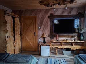 a room with a television and a room with two beds at Lukin salaš broj 3 in Ratkovo