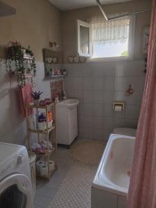 a small bathroom with a tub and a sink at Kikas Stone House in Ávaton +13 photos