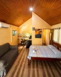 a bedroom with a bed and a couch in it at Ballena Oasis Homes & Glamping in Uvita