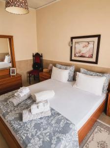 a bedroom with a large bed with towels on it at Kikas Stone House in Ávaton