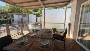 a wooden table on a deck with a tableablish at Camping Delfino in Albenga