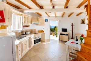 a large kitchen with white cabinets and a table at Villa Windmill in Vlachopoulátika
