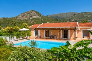 a villa with a pool and mountains in the background at Villa Peach in Katelios