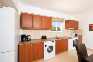 a kitchen with a washing machine and a washer at Villa Peach in Katelios