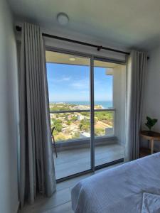 a bedroom with a large window with a view at Exclusivo apartasuite con terraza y vista al mar - Bello Horizonte in Santa Marta