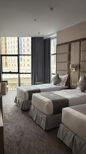 a hotel room with two beds and a large window at سقيا طيبة Suqya Taiba in Medina