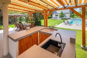 a patio with a kitchen and a backyard with a pool at Lime weekendhouse 1-2 in Balatonakarattya