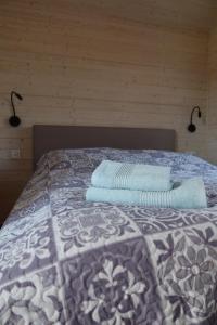 a bedroom with a bed with two towels on it at Domki Paradise Charzykowy in Charzykowy