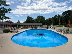 a large blue pool with tables and chairs around it at Hunter's Friend Resort near Table Rock Lake in Branson