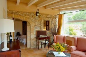 a living room with a bed and a table and a window at El Encinar de Arta in Artá