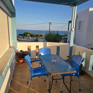 a patio with a table and chairs on a balcony at Soula appartments in Makry Gialos +59 photos