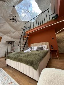 ein Schlafzimmer mit einem großen Bett und einer Treppe in der Unterkunft Skyview Glamping Jacuzzi , Sauna in Ludwinów