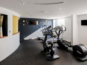 a gym with three tread machines in a room at Novotel Bordeaux Lac in Bordeaux