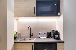 a kitchen with a sink and a microwave at La Maison Solférino in Boulogne-Billancourt +71 photos