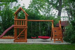 a playground with two swings and a slide at Lime weekendhouse 1-2 in Balatonakarattya