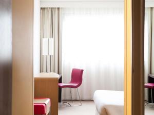 a room with a bed and a chair and a window at Novotel Nantes Carquefou in Carquefou +115 photos